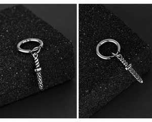 Macro detail of silver stainless steel sword earring with textured hilt and mesh blade