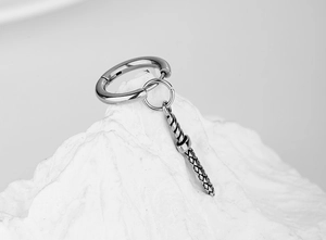 Detail of silver stainless steel hoop earring featuring a textured cylindrical pendant