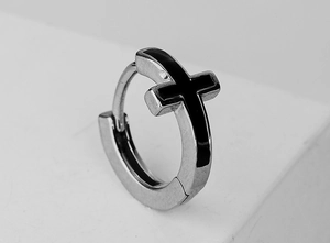 Macro shot of silver stainless steel hoop earring with black enamel cross pattern