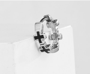 Detail of silver hoop earring with black crosses and classic hinge closure
