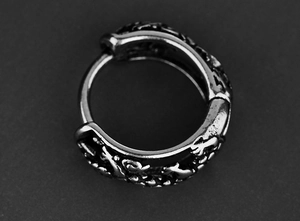 Détail macro d'un anneau vintage en acier avec motifs d'écailles de dragon gravés
