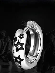 Gros plan de boucles d'oreilles en acier titane argenté avec motifs d'étoiles noires hip-hop