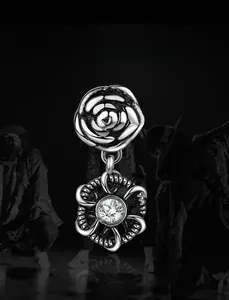 Détail d'une boucle d'oreille étoile en argent avec rose en relief et pierre de zircon