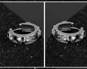 Dettaglio di orecchini a cerchio gotici con teschi in finitura argento vintage e rilievi