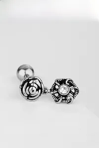 Gros plan sur boucle d'oreille étoile en acier avec rose gravée et pierre de zircone