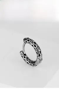 Close-up of vintage style stainless steel earrings with engraved floral relief patterns