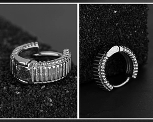 Détail des boucles d'oreilles créoles en acier avec rayures verticales et fermoir cliquet