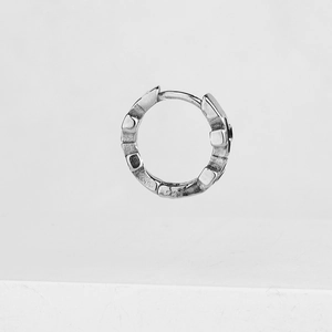 Polished silver geometric hoop earrings with textured 3D block design on white background