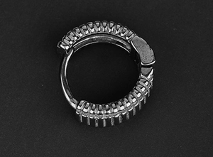 Vue macro d'une créole punk en métal gris avec texture industrielle et fermoir charnière