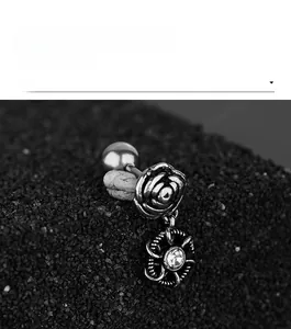 Vue macro d'un piercing ombril en acier argenté vintage avec rose sculptée et cristal
