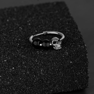 Boucle d'oreille punk tête de mort avec perles noires en acier inoxydable sur pierre