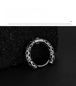 Macro view of vintage gothic silver steel hoop earring with textured relief on black stone