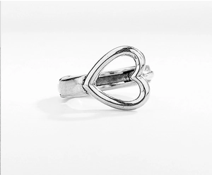Macro shot of silver heart ring with a hollow design and retro brushed metal texture