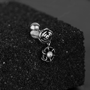 Boucles d'oreilles vintage en acier avec rose et zircon sur un support élégant