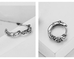 Macro detail of vintage rose vine hoop earrings with antique silver finish and clasp