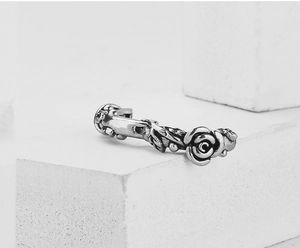 Detailed macro view of vintage silver rose relief and vine texture on steel earrings