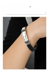 Detailed shot of a black silicone bracelet with a carved silver steel plate on a wrist