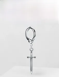 Macro detail of silver sword drop earring with minimalist metal hoop and polished finish
