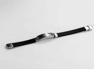 Detail of hollow geometric pattern on stainless steel and black silicone bracelet