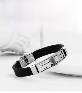 Macro view of stainless steel clasp and engraved heart arrow on black silicone bracelet