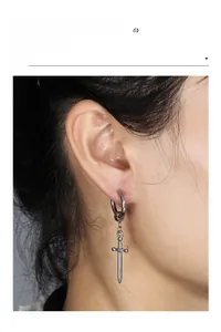 Close-up of silver stainless steel sword earring worn by a male model for street style