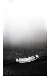 Macro shot of curved stainless steel plate with engraving on a black leather bracelet band