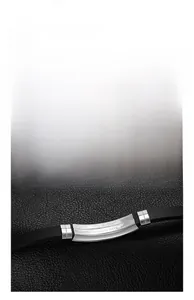 Close-up of polished hollow stainless steel plate on black silicone men's bracelet