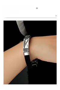 Close-up of men's stainless steel and black silicone bracelet with engraved metal buckle