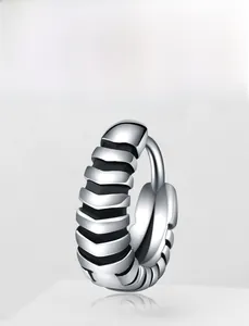 Close-up of silver steel hoop earring featuring industrial ridged texture design