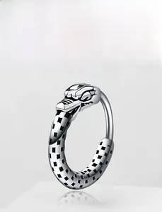 Macro shot of punk style stainless steel dragon head earring with black grid patterns