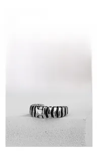 Macro detail of industrial silver steel ring with vertical black bone-like grooves