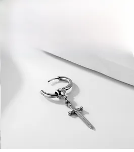 Macro shot of silver punk earring with detailed sword pendant and polished ring clasp