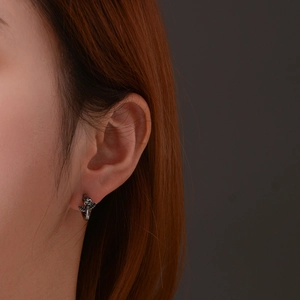 Minimalist vintage rose stud earring in stainless steel worn by a model in a close-up shot