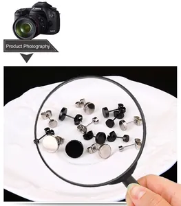 Detail of silver and black stainless steel stud earrings shown under a magnifying glass