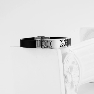 Hollow stainless steel men's bracelet with black silicone band on white background