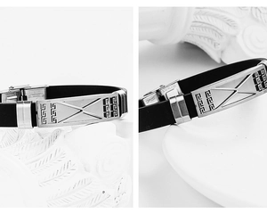 Detail of stainless steel clasp and Greek key pattern on black silicone bracelet