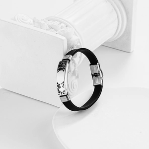 Men's hollow stainless steel and black silicone bracelet on a white display stand