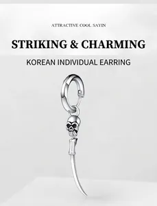 Detail of gothic stainless steel earring with skull pendant and sharp curved spike