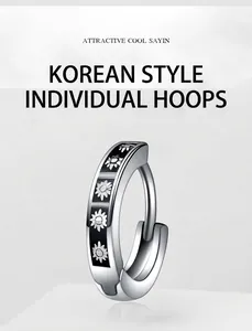 Macro view of silver stainless steel hoop earring with black enamel and daisy motifs
