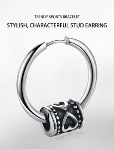 Detail of a stainless steel hoop earring with a sliding hollow heart charm and retro texture