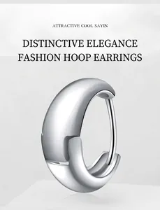 Macro shot of minimalist silver metal earrings with sleek curved industrial aesthetic