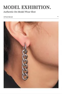 Détail de boucles d'oreilles en maille cubaine argentée avec un design industriel épuré