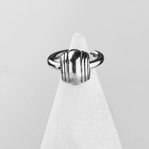 Bague minimaliste en acier inoxydable argenté avec texture vintage sur un cône blanc