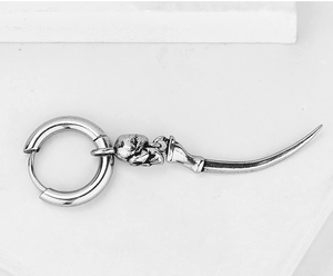 Detailed view of silver gothic skull and curved spike pendant on stainless steel earring