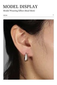 Close-up of minimalist silver teardrop hoop earrings on model with polished finish