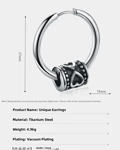Macro detail of silver stainless steel hoop earring with black antique heart charm