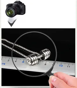 Detailed view of silver dumbbell pendant with size measurement on a dark background