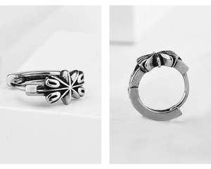 Makro-Detail von Retro-Silber-Creolen aus Stahl mit graviertem floralem Kreuz-Design