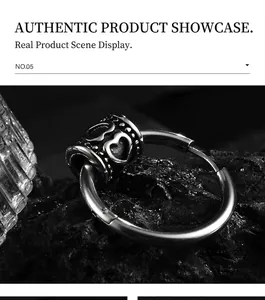 Macro shot of silver steel earring with heart cutout on a black mineral stone