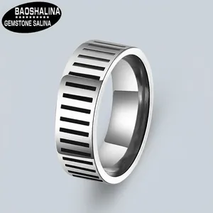 Macro shot of wide stainless steel ring with black industrial stripe pattern